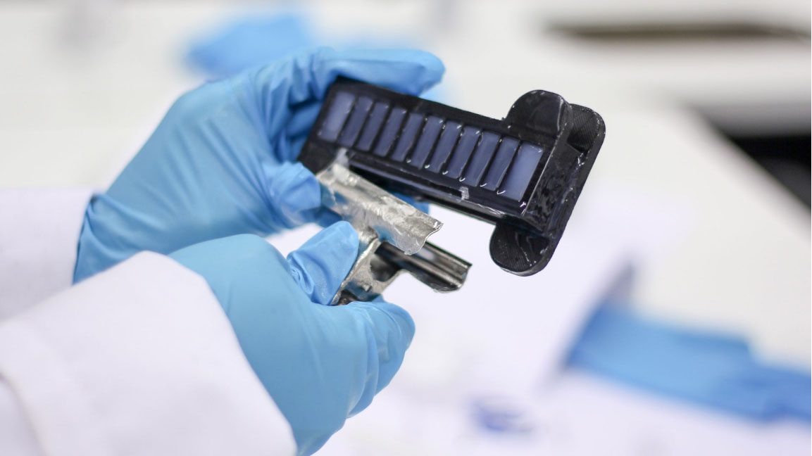Glove covered hand removing silicone from a plastic mold